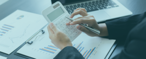 A person holding a calculator and pen.