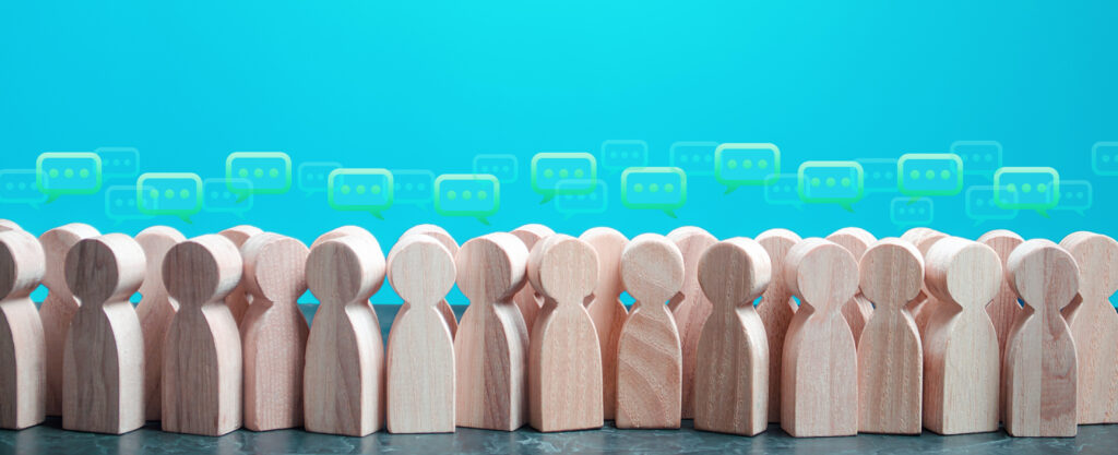 Little wooden human figures with speech bubbles over their heads on a blue-green background.