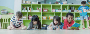 A row of children on the floor reading books